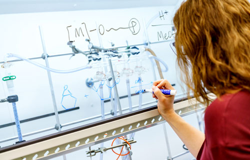 A female student performs an experiment in chemistry lab.