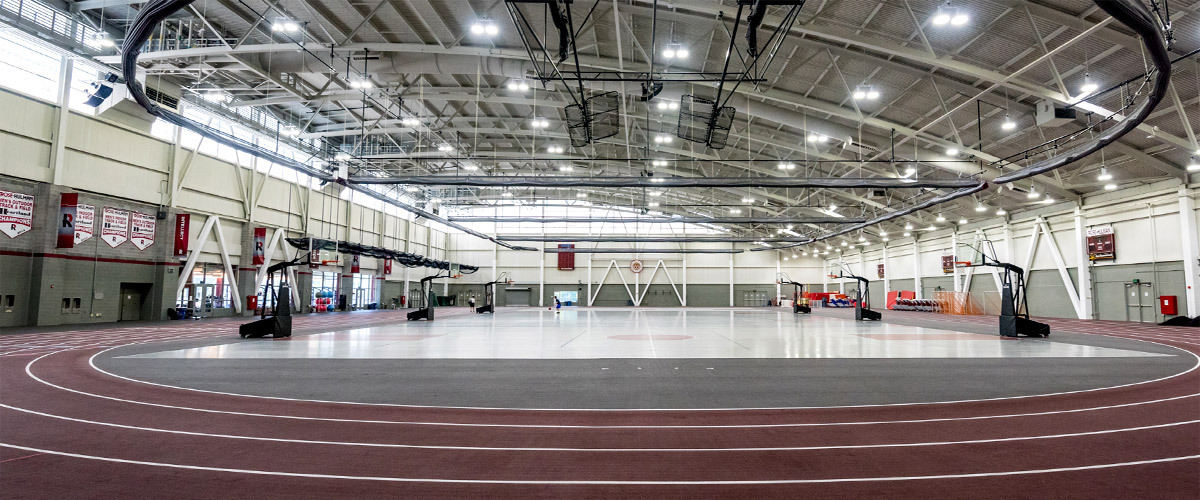 Image shows wide shot of the inside of the SRC fieldhouse, including the track, basketball goals, and the central area used for basketball, tennis, volleyball and other activities.