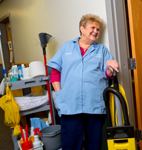 Smiling housekeeper in a residence hall.