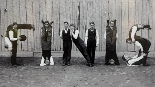 Historical photo showing students forming the word “finis” with their bodies.