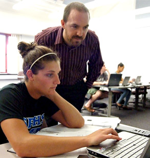 Dr. McClellan works with female student in classroom.