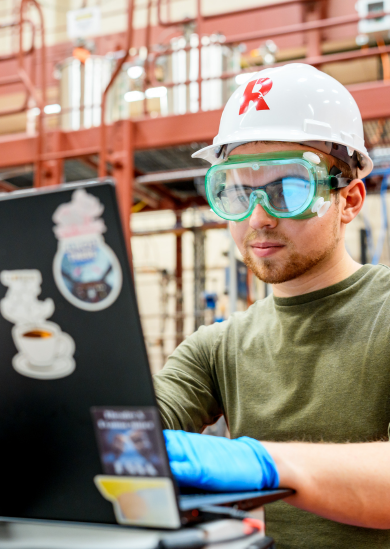 Female student wearing hard hat works in High Bay Lab.