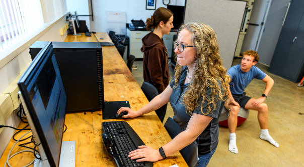 Two students and a professor conduct research inside a biomedical engineering laboratory. 