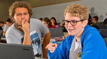 Student explains computer program to another student, who looks doubtful about the whole thing.