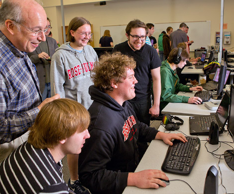 Students and a teacher watch another student as he works at a computer inside one of Rose-Hulman’s computer labs.