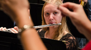 Student playing the flute during a performance in Hatfield Hall. 