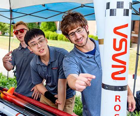 Students pointing to Nasa rocket
