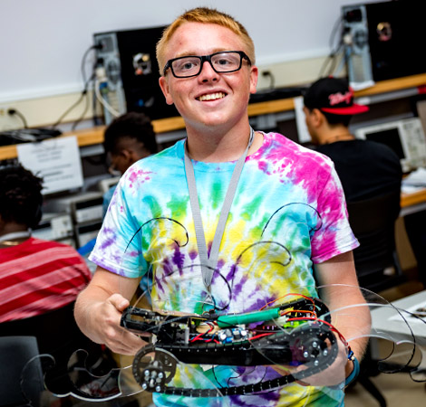 Student holds robotic vehicle.
