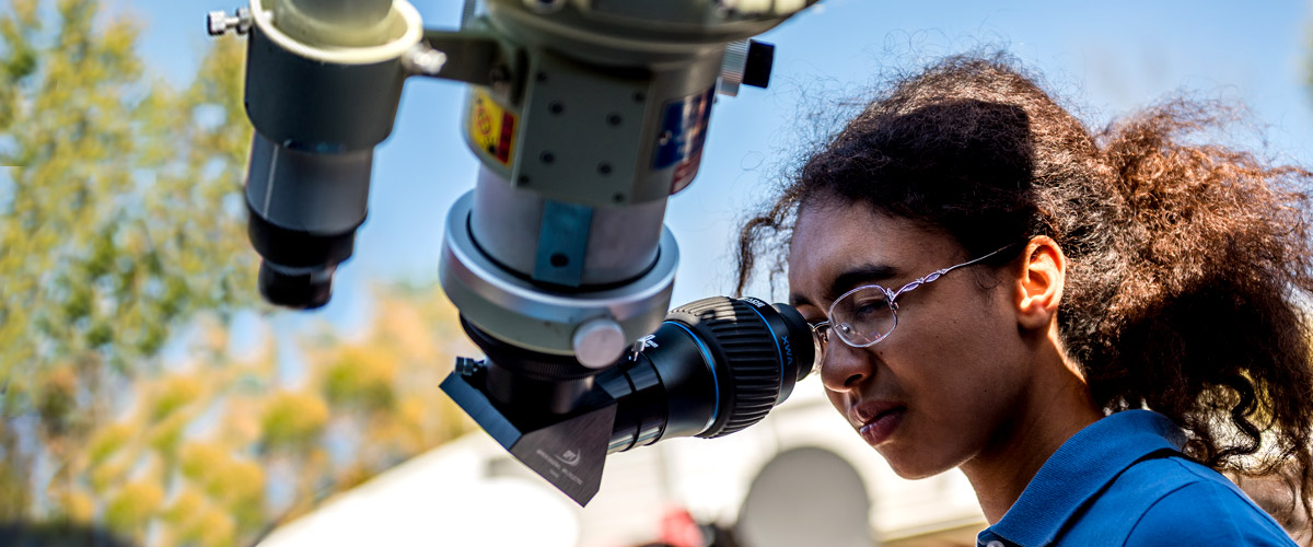 Female student looking into an Oakley Observatory telescope.