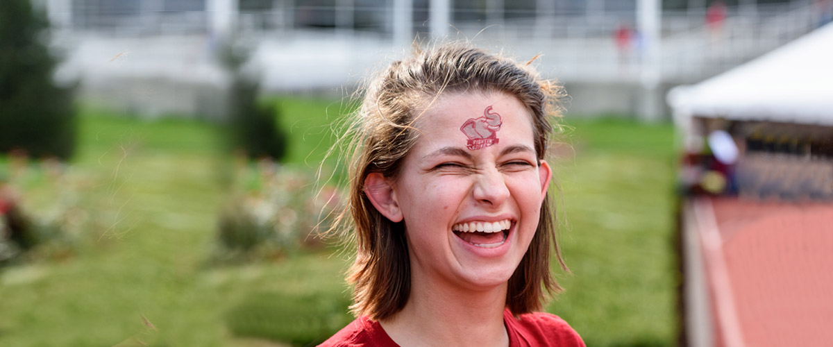 !Girl's face with big smile. She has elephant tattoo on her forehead.