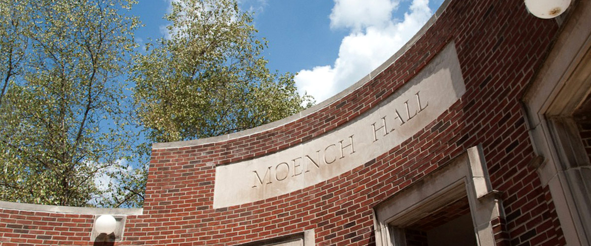 The entrance to Moench Hall against a blue sky. Moench Hall is one of the academic buildings on campus and home to several academic departments and their faculty.