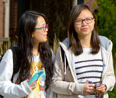 !Two female international students walking on campus