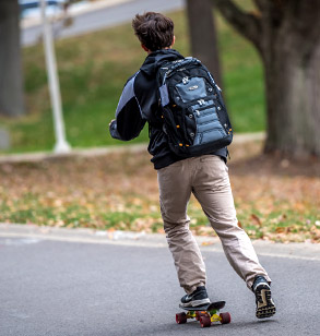 Student rides a skateboard on campus