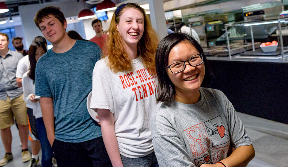 Smiling students line up for lunch in the cafe