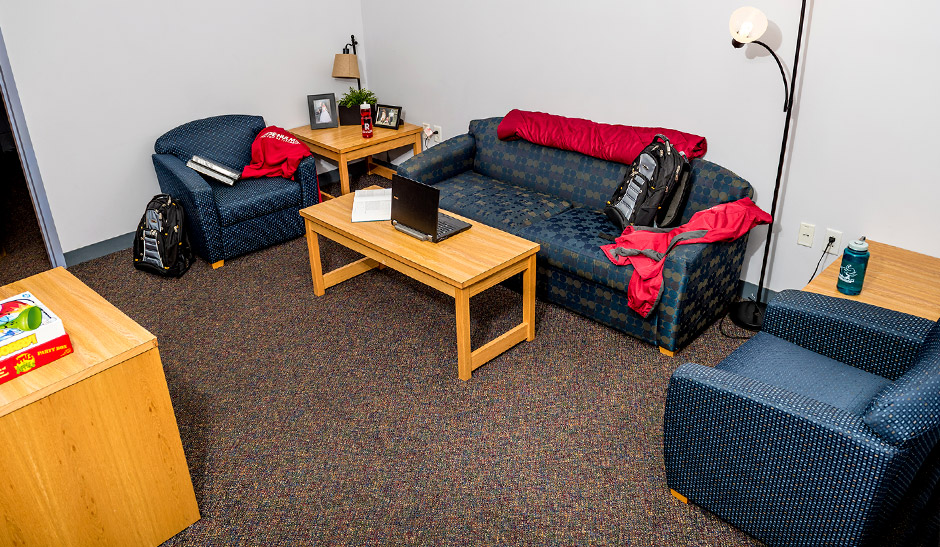 Couch, chairs, and tables in a living room in a typical suite in the Apartments
