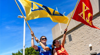 Greek Games team members waving Greek flags