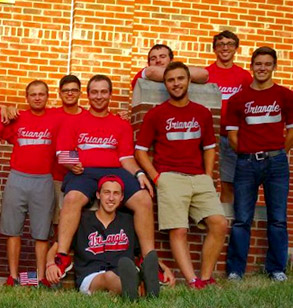 Members of the Triangle fraternity pose outside their fraternity house wearing their red colors.