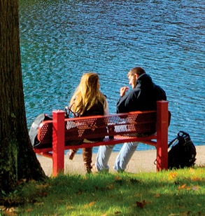 Two students sitting on a bench near Speed Lake.