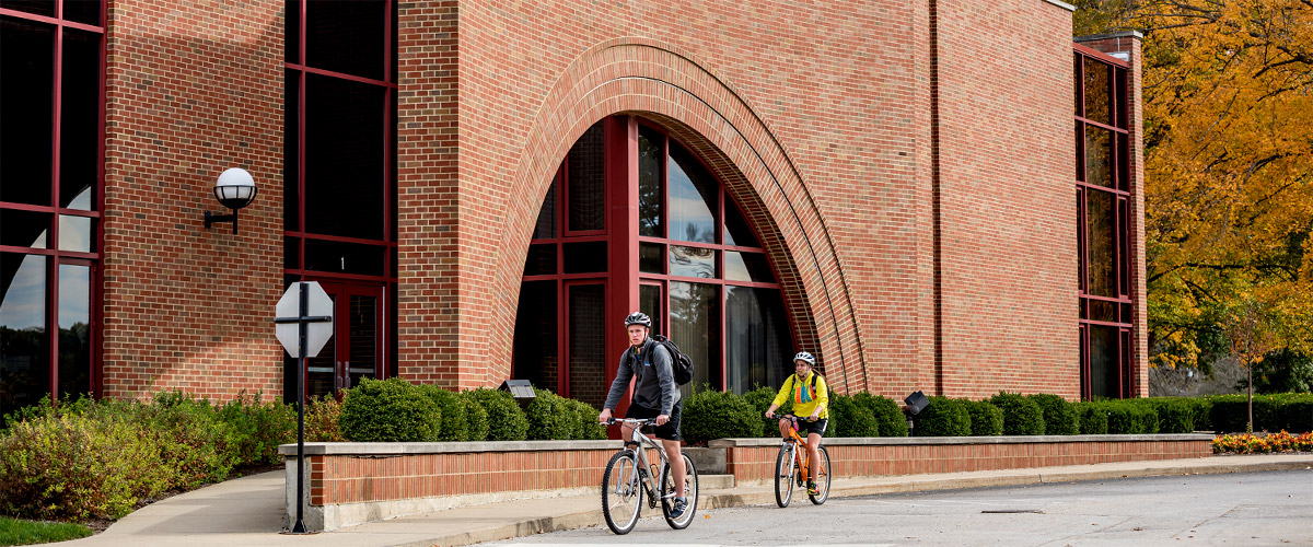 Students bicycling near Olin Advanced Learning Center.