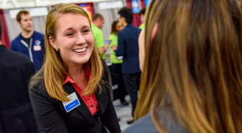 !Female student meets with recruiter at Career Fair.