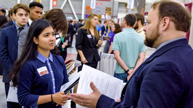 Student meeting with company representative at the fall career fair.