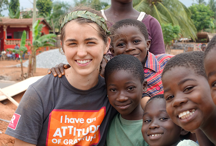 Female student posing with African children on an Engineers Without Borders trip