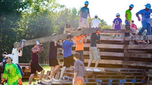 Rose-Hulman students carrying railroad ties to build a massive homecoming bonfire.