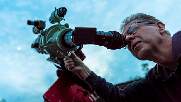 Female student looking through telescope