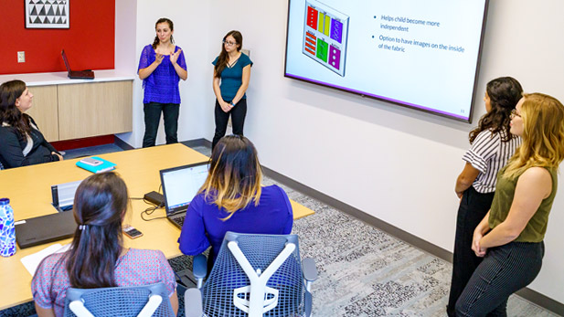 Female students presenting their capstone design project.