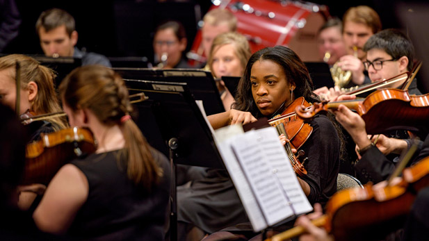 Students performing with the orchestra