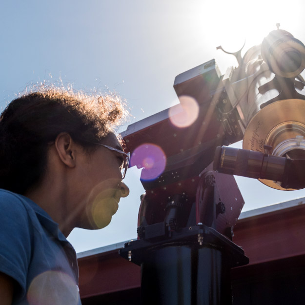 Student looking through a telescope