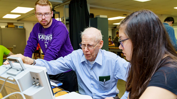 Professor Moloney working with a pair of students.