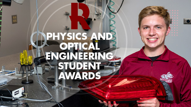 Physics student Cody Brelage smiling and holding his physics and optical engineering project.