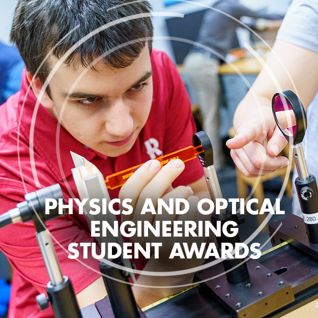 Physics student Cody Brelage smiling and holding his physics and optical engineering project.