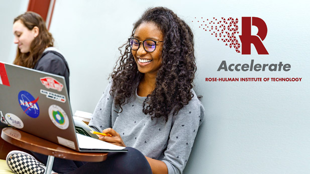 Image shows female student smiling and working on her Rose-Hulman laptop.