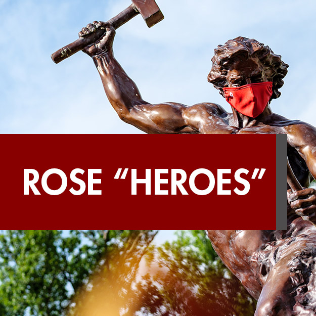 Image shows sculpture of the self-made-man wearing a COVID-19 mask above the words Rose Heroes.