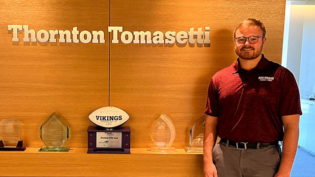 Hunter Crumly standing in front of a trophy case.