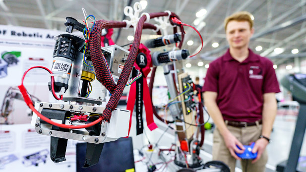 Student demonstrates a robotic arm at the Rose Show.