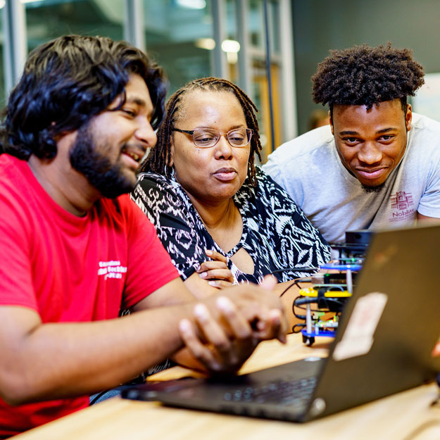 Carlotta Berry works with students at a computer.