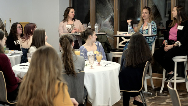 A group of Rose-Hulman students and alumnae meet in a room for a Women in STEM panel.