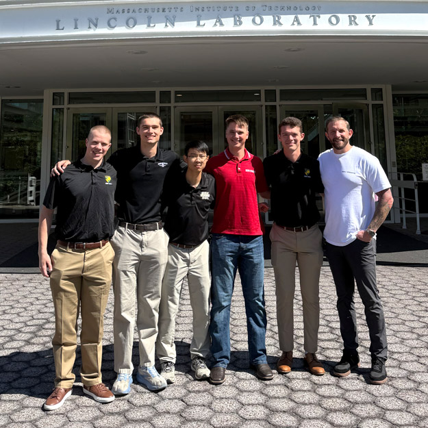 Matt Neville, Cobi Harris, Lifu Zhang, Collin Rogers and Josh Willeke stand alongside Richard Franko outside MIT Lincoln Laboratory.