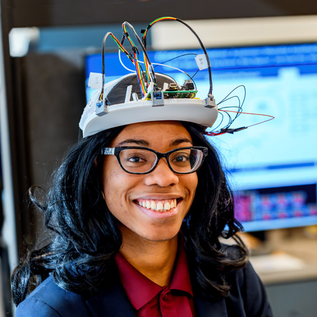 Five Rose-Hulman students pose with their senior design project during a presentation session.
