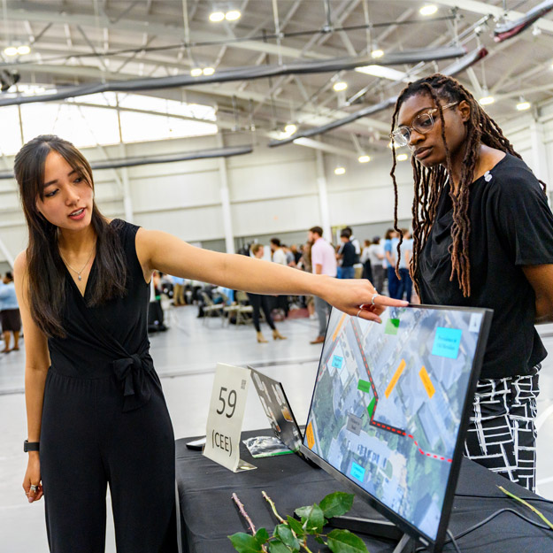 Two students present their civil engineering project at the Rose Show. 