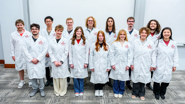 Rose-Hulman students wearing white lab coats with their names and the Rose-Hulman logo embroidered. 