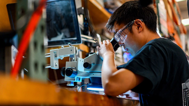 A student wearing googles looks into a scope in the BIC.