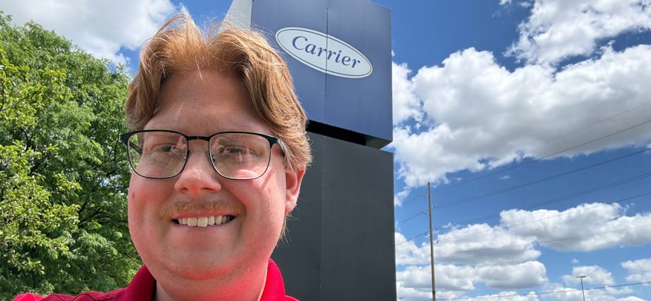 Jacob Childres takes a selfie by the Carrier Corporation sign.