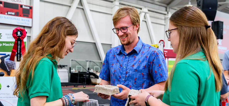 A student demonstrates the paper pulp molds to other students at the Rose Show.