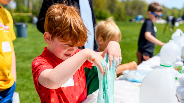 A child plays with slime during a science experiement.
