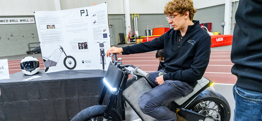 A student rides the electric motorcycle inside the SRC.