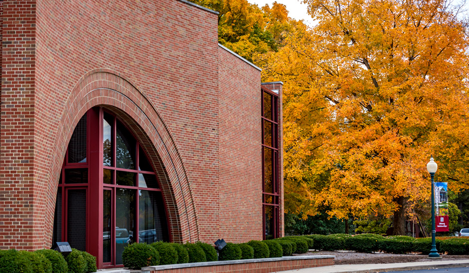 New Olin Hall exterior on a fall day with colorful tree next to the building.